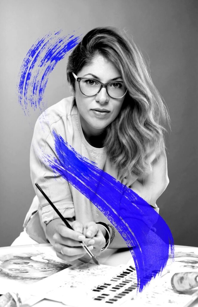 Retrato de Norelys Correa en blanco y negro, con un pincel en la mano y un trazo azul cruzando la imagen